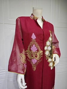 Detailansicht der goldenen Stickereien und Pailletten auf einem kastanienbraunen Abendkleid