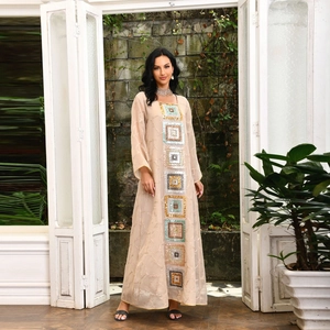 Detail of elegant beige bohemian maxi dress with colorful sequined geometric embroidery