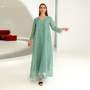 Detail of mint green mesh abaya featuring silver embroidery and floral jewel buttons