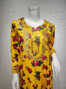 Detail of vibrant yellow ethnic dress featuring intricate gold embroidery and sequins