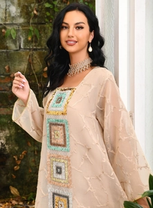 Close-up of beige ethnic dress featuring multi-color sequin embroidery and sheer texture