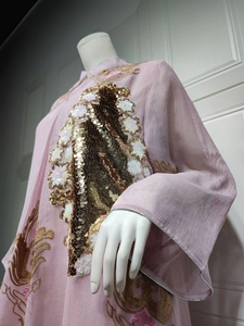 Nahaufnahme mit aufwendigen goldenen Pailletten und Stickereien auf einem rosa Abendkleid