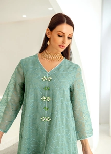 Detail of mint green mesh embroidery dress with V-neck and 3D floral jewel buttons