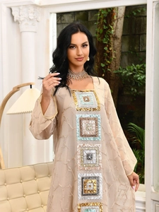 Detailed embroidery on beige sequined dress with metallic accents and sheer texture
