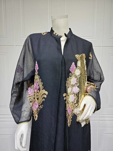 Detailansicht der aufwendigen gold- und rosa Paillettenstickerei auf einem schwarzen Abendkleid