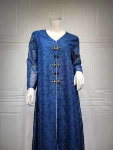 Detail of dark blue V-neck kaftan with mesh embroidery and flower diamond buttons