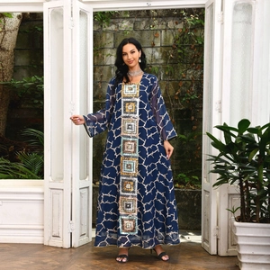Close-up of a blue long-sleeve kaftan dress with sequin embroidery and abstract patterns