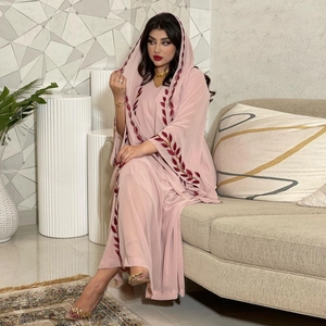 Detail of pink chiffon abaya with intricate dark red leaf embroidery and matching hood