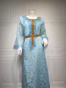 Detail eines hellblauen Kaftans mit Goldtextur, Federbesatz und Paillettengürtel