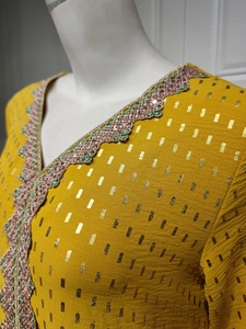 Nahaufnahme des V-Ausschnitts mit Pailletten-Stickerei und Goldfoliendruck am Kleid