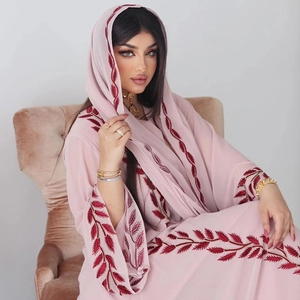 Close-up of intricate red leaf embroidery on a pink chiffon abaya with matching hijab