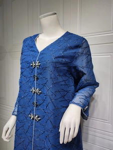 Detail of royal blue ethnic dress featuring intricate bead embroidery and rhinestone buttons