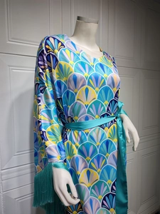 Détail de robe en satin imprimé à manches à franges et ceinture verte