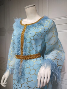 Detailansicht eines hellblauen Kaftans mit Goldstickerei und elegantem Federbesatz