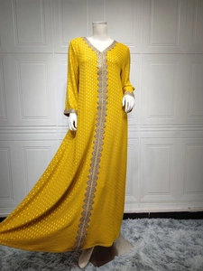 Detail eines gelben Kaftan-Kleids mit Stickerei und goldenen Pailletten-Akzenten
