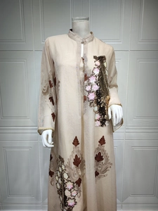 Detailansicht eines beigen Abendkleides mit eleganten Pailletten-Blumenstickereien und Goldbesatz.