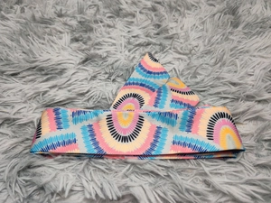 Detail of bohemian geometric print headband with colorful semi-circle patterns on soft fabric