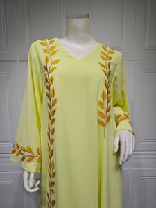 Macro shot of gold leaf embroidery on the neckline and sleeves of the yellow dress