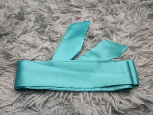Détail du tissu en satin bleu sarcelle avec un éclat élégant et une couture de qualité
