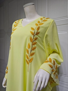 Detail view of golden leaf embroidery on the shoulders of this yellow chiffon maxi dress
