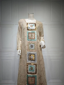 Detail of sequins embroidery on beige long sleeve abaya dress with floral texture