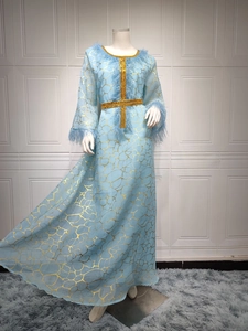 Detail von hellblauem Kaftankleid mit Goldfolientextur und Straußenfederbesatz an Ärmeln