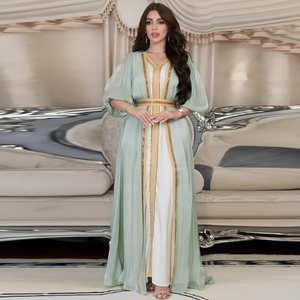 Detail of light green Moroccan kaftan dress featuring gold embroidery and beaded waist belt