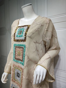 Detail of sequins embroidery and gold piping on a beige sheer tulle ethnic tunic