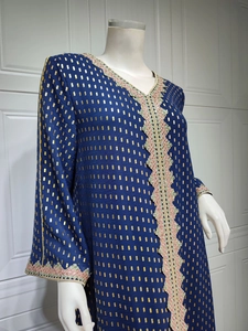 Detail eines dunkelblauen Kaftan-Kleids mit Goldfoliendruck und ethnischer Bestickung