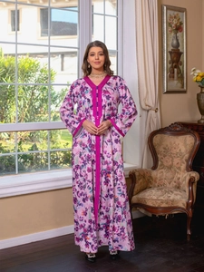 Detail of V-neckline with rose red embroidered trim and buttons on floral kaftan dress
