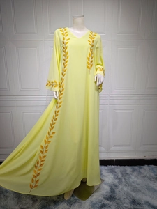 Detail of golden wheat embroidery on yellow chiffon long dress with elegant V-neck design