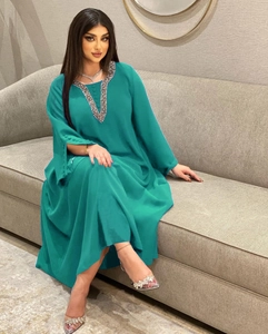 Nahaufnahme des eleganten Kaftan-Kleids mit V-Ausschnitt, Pailletten und Perlen