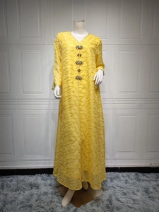 Detailed view of yellow abaya with crystal flower buttons and textured fabric