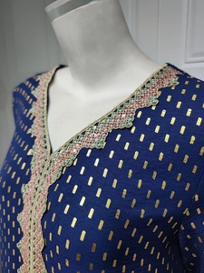 Detail des V-Ausschnitts mit Goldstickerei und Pailletten auf dunkelblauem Kleid