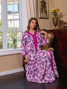Detail of V-neckline with pink wavy trim and buttons on a floral print kaftan dress
