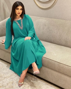 Detail eines blaugrünen Abaya-Abendkleids mit silbernem Kristallbesatz am V-Ausschnitt