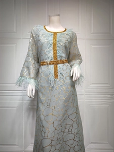 Detail des hellblauen Kleides mit goldenem Gittermuster und luxuriösem Federbesatz