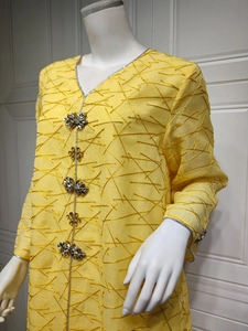 Close-up of yellow ethnic dress featuring gold embroidery and handcrafted rhinestone beadwork