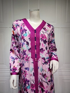 Detail of V-neckline with pink braided embroidery and decorative buttons on floral dress