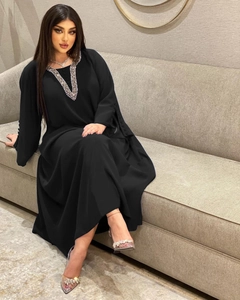 Detailansicht des V-förmigen Strass-Ausschnitts und der Knöpfe am Ärmel des schwarzen Abaya-Kleids