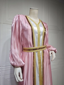 Detailed close-up of pink satin kaftan with golden sequin trim and long lantern sleeves