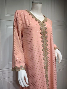 Detail eines rosa Kaftan-Kleides mit Goldfoliendruck und aufwendiger Paillettenstickerei
