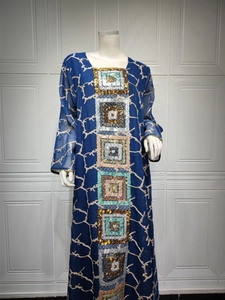Close-up of intricate square sequin embroidery and branch patterns on a navy blue dress