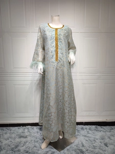 Details des hellblauen Kaftan-Kleids mit Goldmuster und blauem Straußenfederbesatz