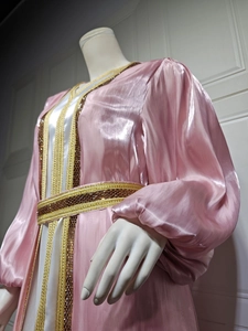 Close-up of pink satin Kaftan with intricate gold embroidery and beaded waist decoration