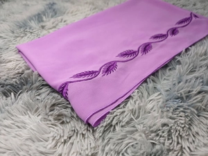 Detail of lavender chiffon hijab featuring elegant dark purple leaf embroidery and soft texture