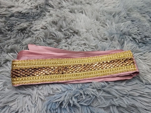 Detailed view of ethnic embroidery on purple satin fabric with gold metallic thread