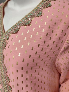 Detailansicht des rosa Kleides mit Goldfolienmotiven und Paillettenstickerei am Hals