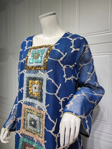 Detail of blue long-sleeve dress with sequins embroidery and branch patterns
