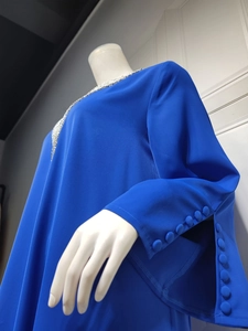 Detail von königsblauem Perlen-Ausschnitt und eleganten Knopfbündchen am Damen-Maxikleid